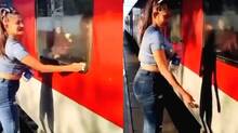 woman-cleaning-train-window-throwing-trash-on-tracks